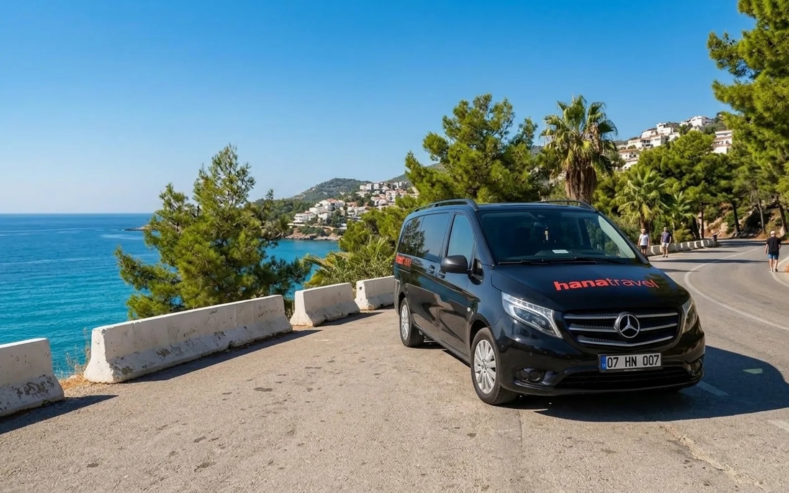 Only your party in the car Black Hana Travel Vito driving along a sunny coast road above turquoise water on the Antalya Riviera — Antalya private transfer